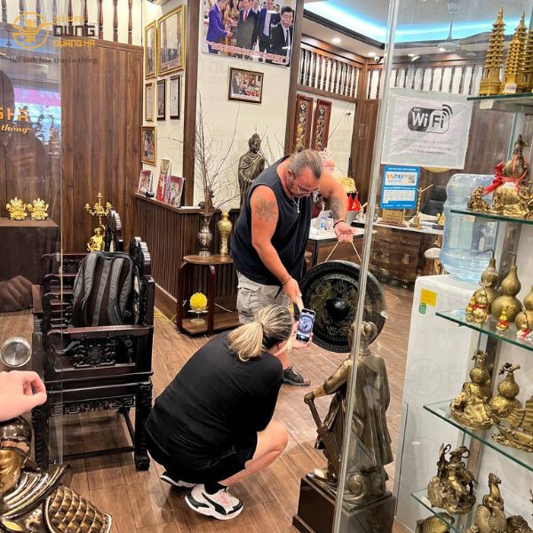 Đồ đồng Dung Quang Hà đón tiếp khách nước Pháp mua Chiêng Đồng tại cửa hàng