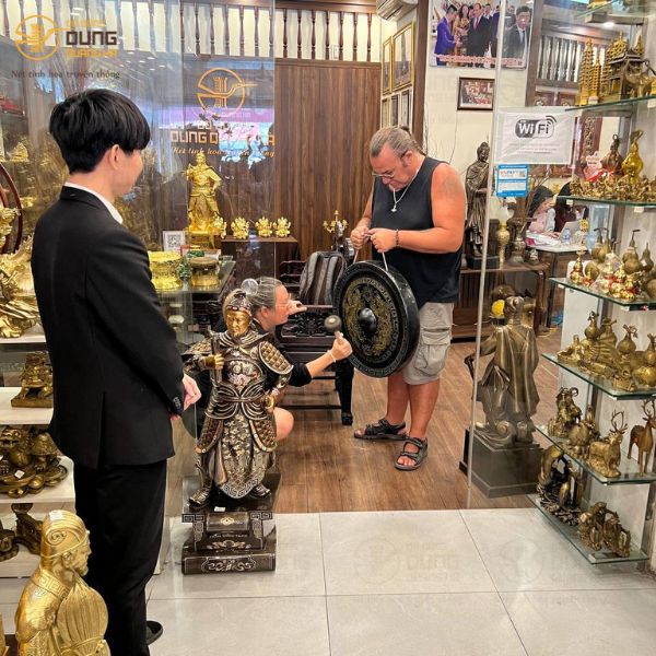 Đồ đồng Dung Quang Hà đón tiếp khách nước Pháp mua Chiêng Đồng tại cửa hàng