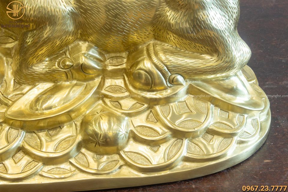 Tượng trâu đồng phong thủy nằm trên tiền bằng đồng catut